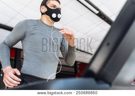 Beautiful Pumped Up Young Man, Engaged In Sports, In Training Mask For Breathing On The Treadmill, M