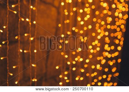 Many Blurred Small Electric Bulbs On A Wall. Yellow Blurred Lights. Wall Of Christmas Lights