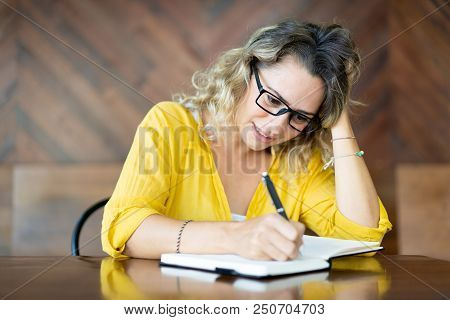 Hectic Young Woman In Glasses Writing Agenda For Meeting. Nervous Female Student Doing Homework At C