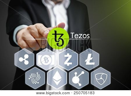 Concept Photo  Business Man Points His Finger At  Tezos Icon Cryptocurrency
