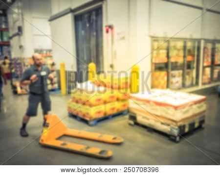 Worker With Manual Forklift Stockpile Goods Near Cold Storage Room In Wholesale Store