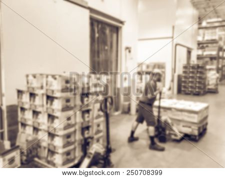 Worker With Manual Forklift Stockpile Goods Near Cold Storage Room In Wholesale Store