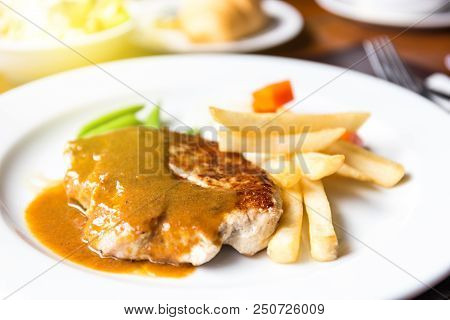 Pork Chop Steak With Dilicious Sauce And French Fries On The Pork In Lunch Time