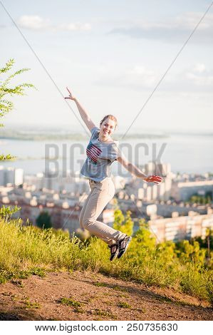 Portrait Of A Woman In An American T-shirt On The Background Of Saratov, Russia, View Of The Houses,