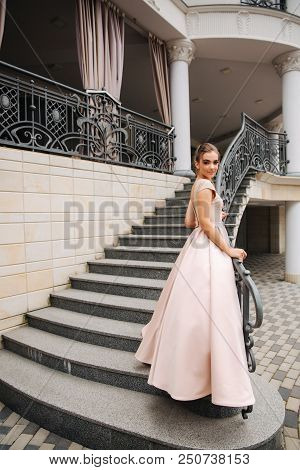 Elegant Lady Satnd On Stairs In Front Of Restaurant.