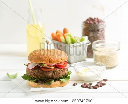 Vegetarian Bean And Quinoa Burger With Fresh Vegetables And Lemonade On The Table