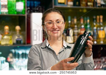 Professional Bartender Girl Holding In Hands A Shaker With A Fresh Delicious Cocktail. Barmaid Shaki