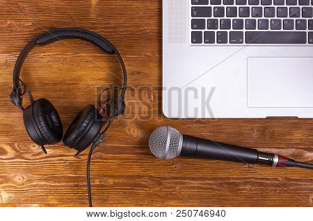 Laptop Microphone Headsets On A Wooden Table Background