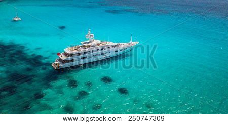 Big luxury yacht anchoring in shallow water, aerial view. Active life style, water transportation and marine sport.