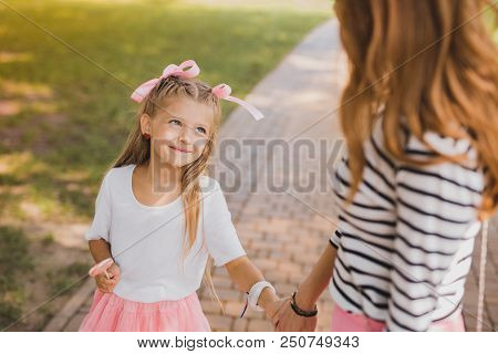 Appealing Mother. Unbelievably Cute Loving Daughter Looking At Her Appealing Mother While Walking To
