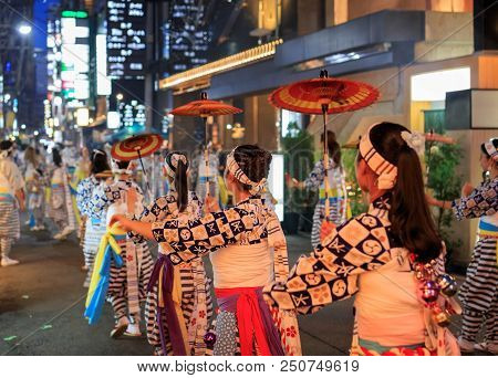 Osaka, Japan - July 23, 2018: Young Women With Red Paper Umbrellas Perform Traditional Dance In Stre