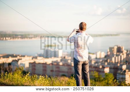 A Man In A Shirt And Trousers Takes Pictures Of Himself And Nature On The Phone. Portrait Of A Man I