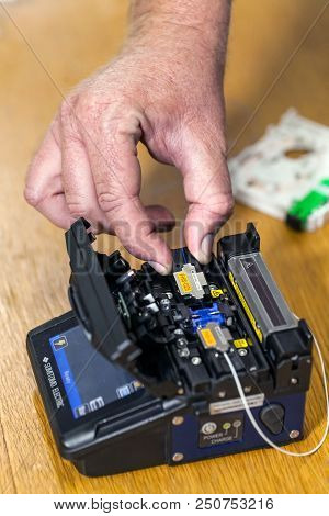 Hand Placing Switch Into Fiber Optic Splicer.