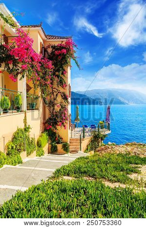 House With Flowers On Coast Of Kefalonia Island In Assos Village, Greece