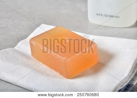 A Bar Of Lavender Infused Glycerin Soap On A Towel By A Bottle Of Shampoo