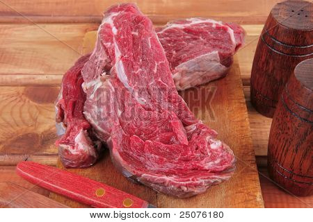 savory: uncooked raw bloody beef meat steak before cooking on wood