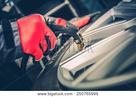 Tire Air Pressure Adjustment. Car Tires Maintenance. Closeup Photo.