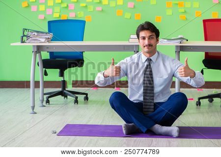 Man in the office with many conflicting priorities doing exercis