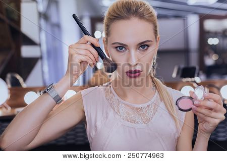 Coloring Cheekbones. Blue-eyed Businesswoman Coloring Her Cheekbones While Getting Ready For Importa