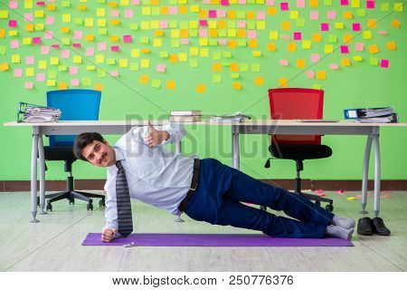 Man in the office with many conflicting priorities doing exercis