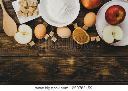 Flat Lay Of Ingedients For Apple Pie On Rustic Wooden Background. Copy Space