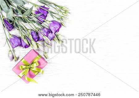 Pink Gift Box And Purple Flowers On White Background. Summer Flowers  Eustoma. Copy Space. Top View