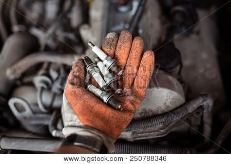Mechanic Holding Old Broken Car Spark Plugs