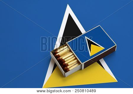 Saint Lucia Flag  Is Shown In An Open Matchbox, Which Is Filled With Matches And Lies On A Large Fla