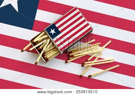 Liberia Flag  Is Shown On An Open Matchbox, From Which Several Matches Fall And Lies On A Large Flag