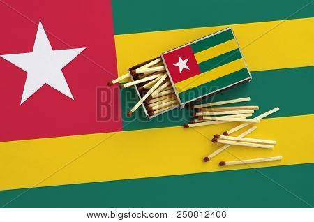 Togo Flag  Is Shown On An Open Matchbox, From Which Several Matches Fall And Lies On A Large Flag.