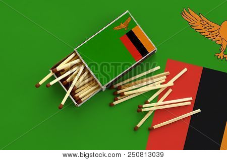 Zambia Flag  Is Shown On An Open Matchbox, From Which Several Matches Fall And Lies On A Large Flag.