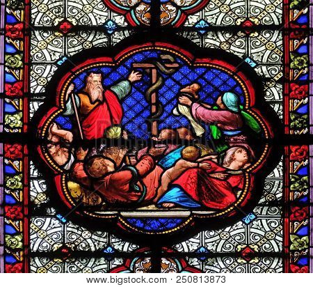 PARIS, FRANCE - JANUARY 05, 2018: Exposition of the brass serpent in the desert, prefiguration of the Crucifixion, stained glass window in the Basilica of Saint Clotilde in Paris, France.