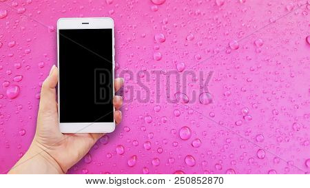 Mockup Image Of Hands Holding White Mobile Phone With Pink Water Drops Background