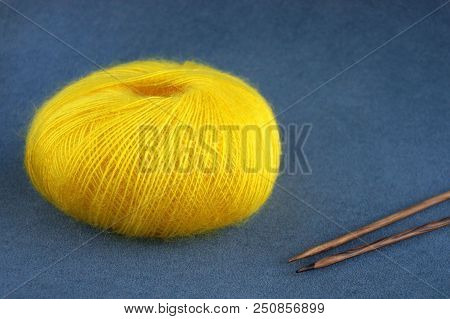 Yellow Yarn Ball Of Mohair (angora) Wool For Knitting With Knitting Needles  
On The Velvet Backgrou