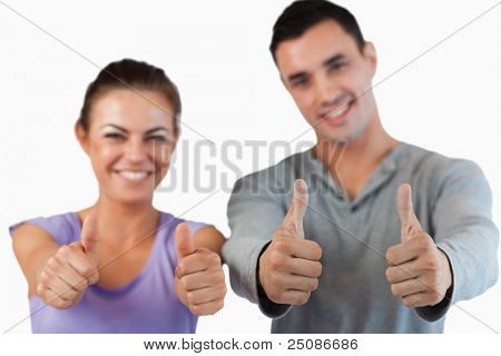 Thumbs up essendo dato dalla coppia contro uno sfondo bianco
