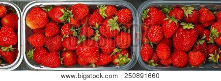 Close Up Of Fresh Red Ripe Strawberries In Transparent Plastic Container Boxes On Retail Market Disp