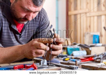 Sculptor Is Giving Stance, Attitude To His Figures Made Of Metal Wire In His Workshop.
