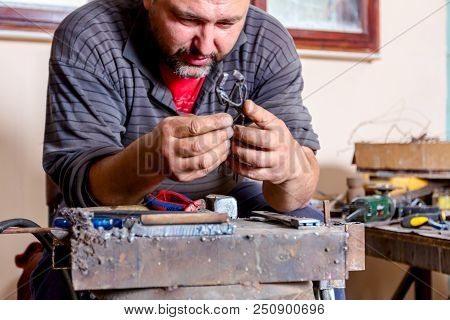 Sculptor Is Giving Stance, Attitude To His Figures Made Of Metal Wire In His Workshop.