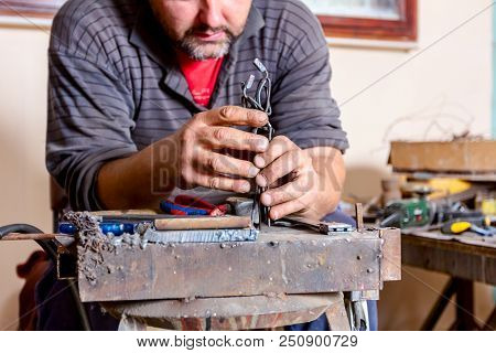 Sculptor Is Giving Stance, Attitude To His Figures Made Of Metal Wire In His Workshop.