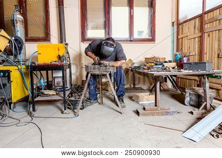 Sculptor Is Using Arc Welding To Assembly Metal Sculpture Barehanded With Protective Mask.