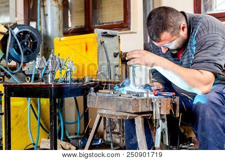 Sculptor Is Using Arc Welding To Assembly Metal Sculpture Without Proper Protection, Barehanded.
