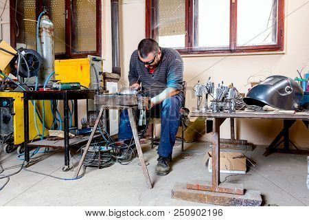 Sculptor Is Using Arc Welding To Assembly Metal Sculpture Barehanded With Protective Spectacles.
