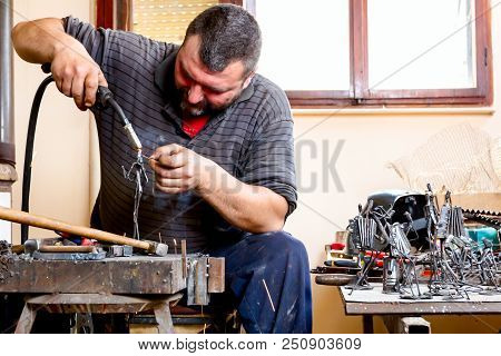 Sculptor Is Using Arc Welding To Assembly Metal Sculpture Without Proper Protection, Barehanded.