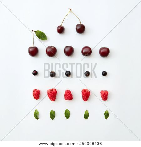 Fruit pattern of fresh berries and greem leaves on white background. Flat lay.