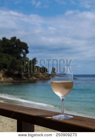 A Glass Of Rose On A Wooden Pier. Sea And Sky. Vertical.