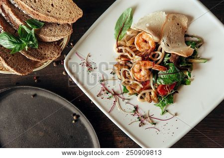Seafood Salad With Shrimps And Squid In Composition With Bread At Dark Wood Background