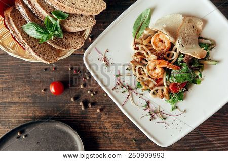 Seafood Salad With Shrimps And Squid In Composition With Bread At Dark Wood Background