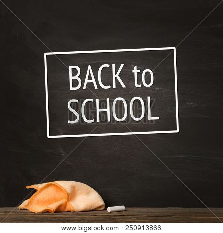 Black Chalkboard. Chalk And Rag Lie Against. Concept: Back To School Background. Text , Inscription