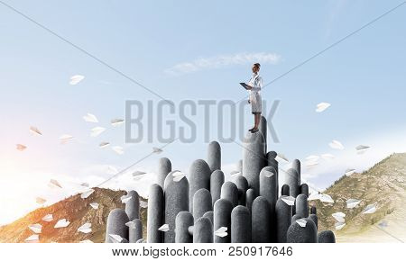 Young Female Doctor With Folder In Hands Satnding On Stone Column