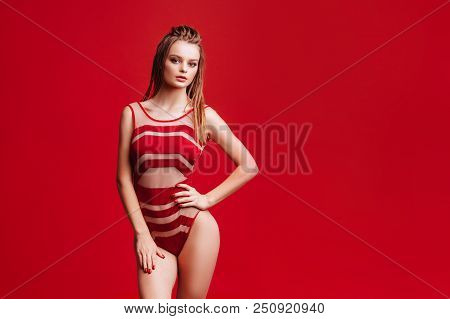 Pretty Bikini Model In Studio On Red Background